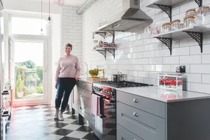 Maxine’s kitchen was installed by Studio One South West to her own design. She opted for a linear layout with deep, sturdy, charcoal-grey drawers. The Smeg Portofino chimney hood, exposed steel venting duct and brick-tiled wall add an industrial vibe. For colour, the pendant lights combine pink glass shades with red flexes Home makeover: 'I started each room with something I love'