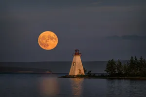 The July Supermoon rises near the Kidston Island Lighthouse on Kidston Island, located in the Bras d’Or lakes in Baddeck, Nova Scotia, Canada See the Super Hunter's Moon 17 October 2024. Credit: Diana Robinson Photography / Getty images