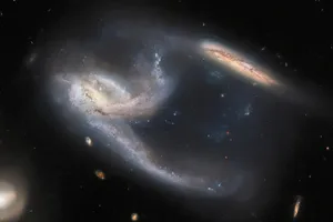 Galaxy triplet NGC 7764A in the constellation Phoenix, captured by the Hubble Space Telescope Credit: ESA/Hubble & NASA, J. Dalcanton, Dark Energy Survey, DOE, FNAL, DECam, CTIO, NOIRLab/NSF/AURA, ESO. Acknowledgement: J. Schmidt Galaxy triplet NGC 7764A in the constellation Phoenix, captured by the Hubble Space Telescope Credit: ESA/Hubble & NASA, J. Dalcanton, Dark Energy Survey, DOE, FNAL, DECam, CTIO, NOIRLab/NSF/AURA, ESO. Acknowledgement: J. Schmidt