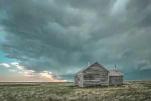 Old abandoned structure on the Great Plains with Storms Inbound Old building on the Great Plains with storm clouds long ago abandoned outside of Hardin Montana at sunset.