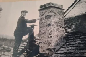 Garfield Evans header Garfield Evans on a roof repairing a chimney