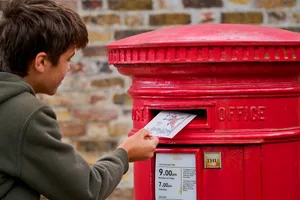 Photograph of a little boy posting a postcard in a postbox Photograph of a little boy posting a postcard in a postbox