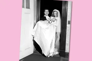 Groom Carrying Bride Over Threshold In Nashville Black and white photograph of a groom carrying a bride over the threshold