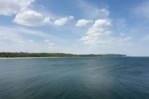 Sopot, Poland. A view of the Sopot coastline featuring the vast Baltic Sea in the foreground and the sandy beach bordered by the extensive green belt and Tri-City Landscape Park forest line behind the city in Sopot, Poland.