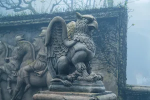 A stone statue of a ferocious griffin. A statue of a mythical animal standing in a misty garden Anastasia Korchagina/Getty Images