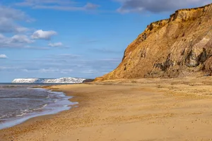 A view along a deserted beach on the Isle of Wight, with Freshwater Bay in the distance Looking towards the cliffs at Freshwater Bay, on a sunny summer's day. Credit: Lemanieh