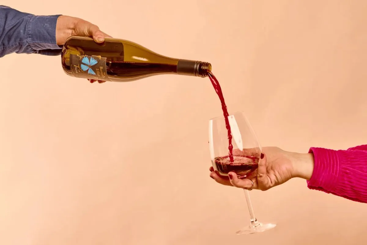 naked-wines-hosting-header A hand pours wine into a glass.