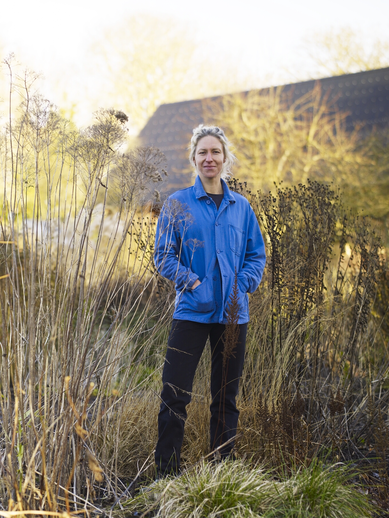 Woman in blue jacket stood in garden