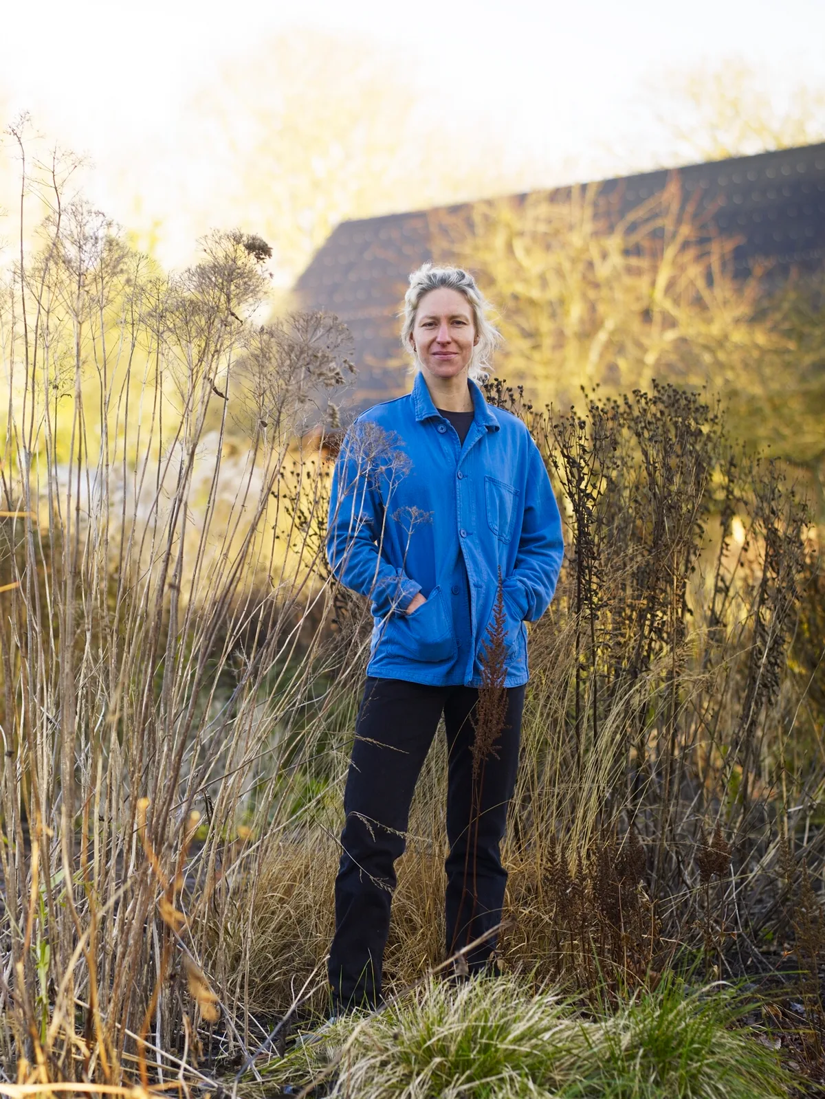 Woman in blue jacket stood in garden