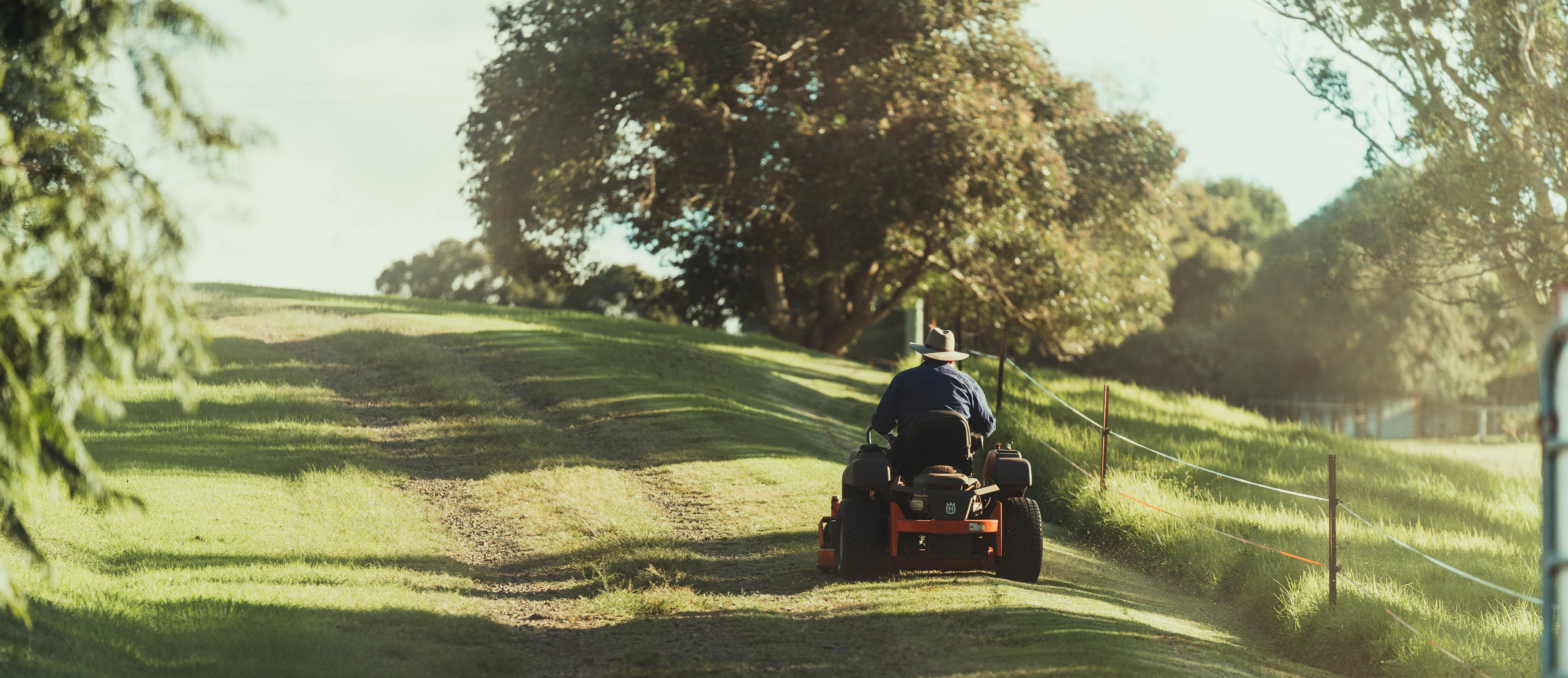 Man on ride on mower in field
