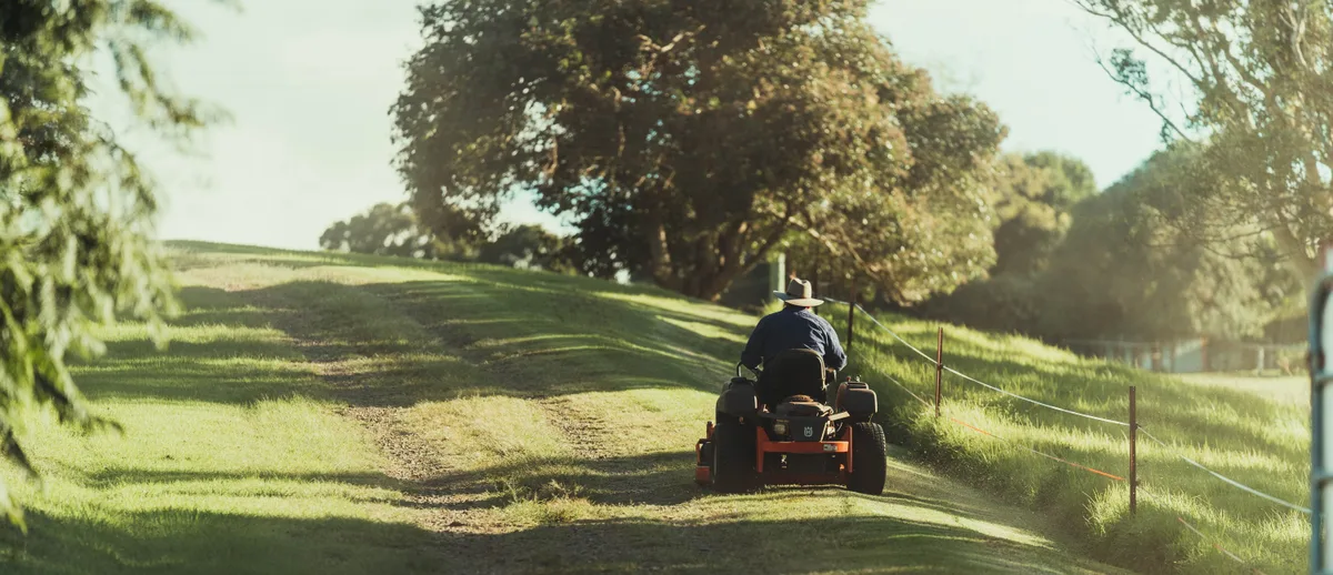 Man on ride on mower in field