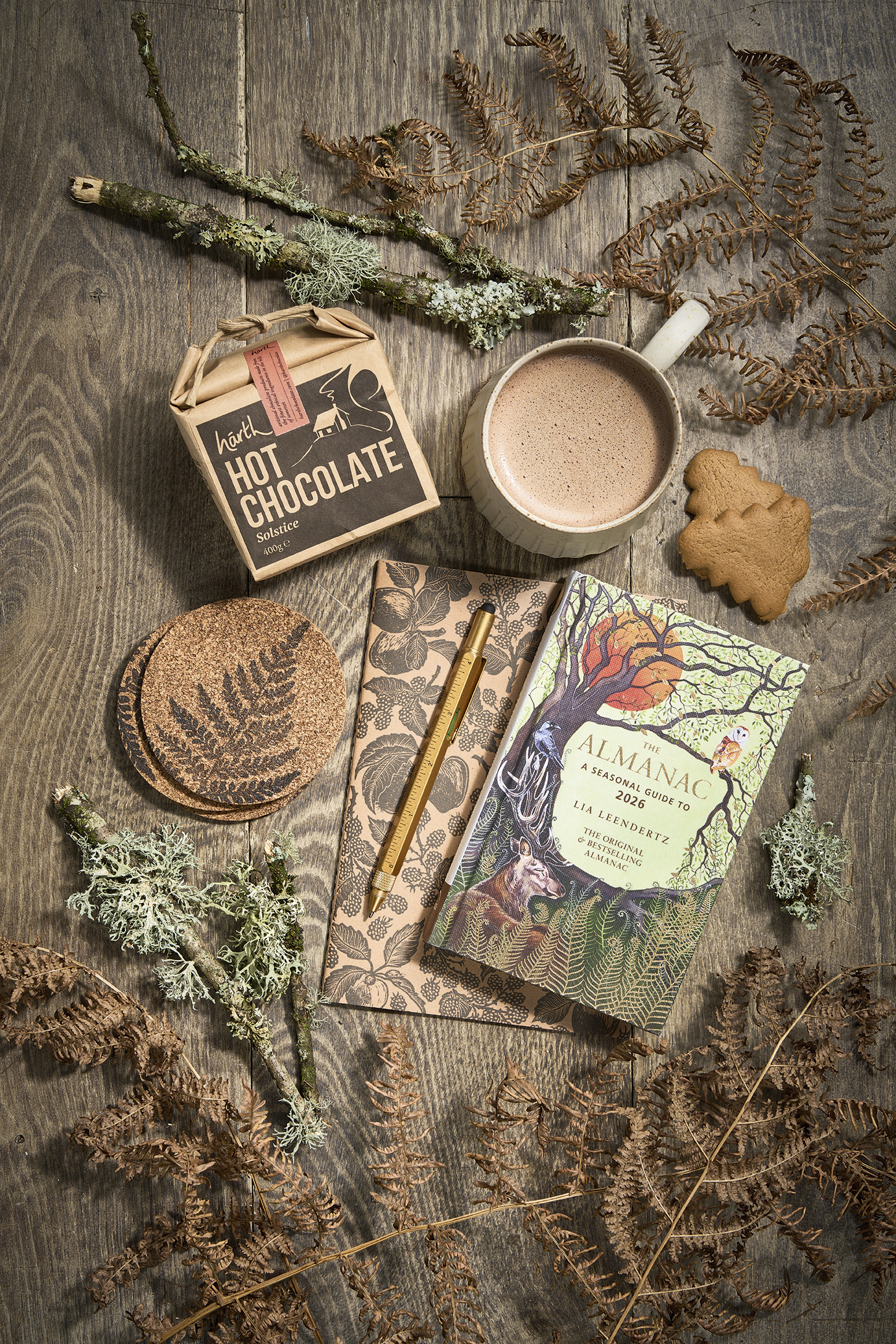 The best gifts for gardeners - Solstice Hot Chocolate, 400g, £8.95, Harth; Bel Holland Fluted Mug, large, £34, The Painted Bird; Gingerbread Christmas Tree Biscuits, 125g box, £3.50, Hawkens Gingerbread; Beth Lewis Linoprint Apple Orchard Notebook, black, A5 plain paper, £6, and Beth Lewis Fern Coasters, black, £12 for four, both These Two Hands; The Almanac: A Seasonal Guide To 2026, by Lia Leendertz, published by Octopus Books £12.99, Waterstones; Workshop Pen, multi-tool, £12, Plümo.