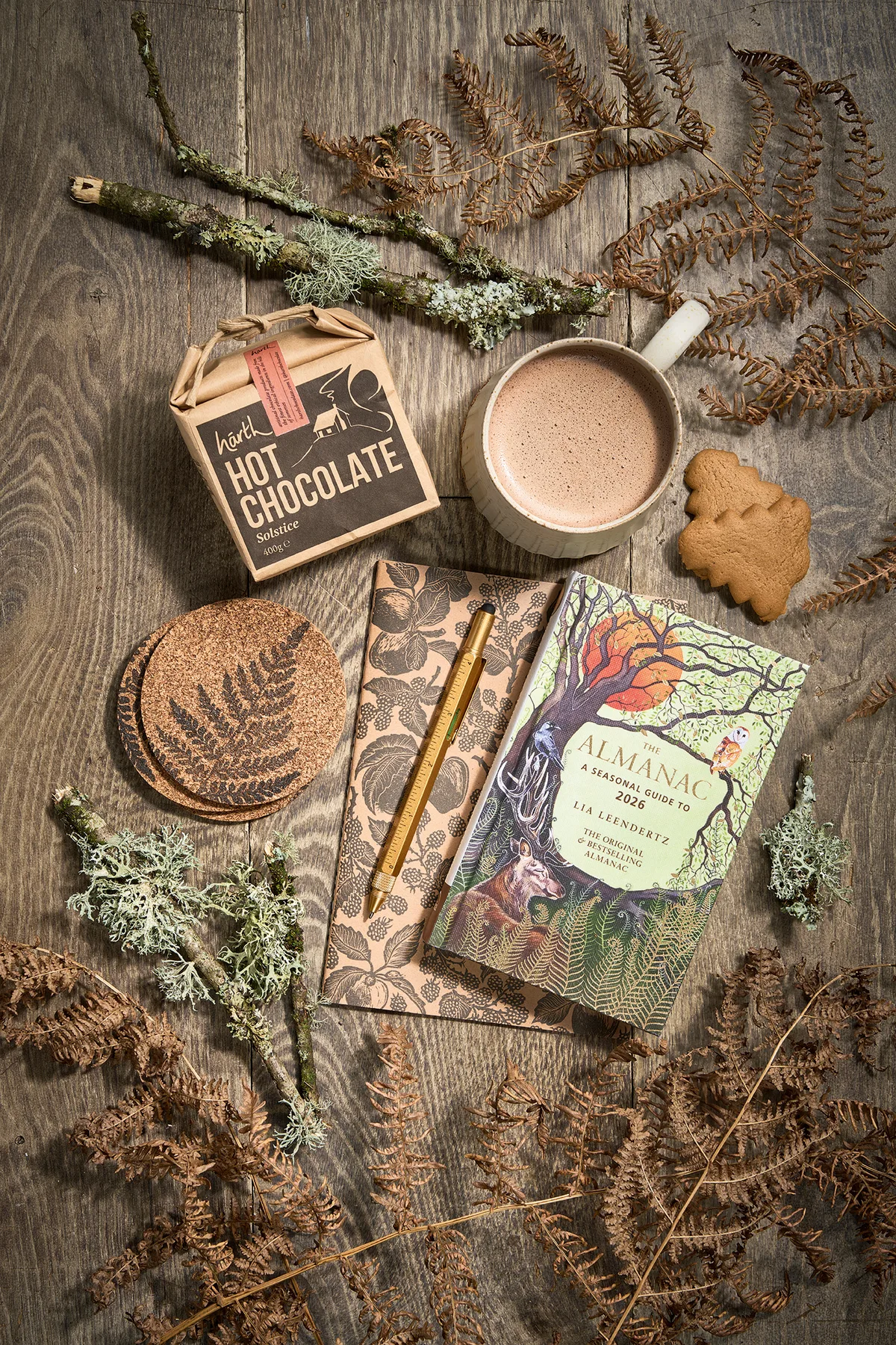 The best gifts for gardeners - Solstice Hot Chocolate, 400g, £8.95, Harth; Bel Holland Fluted Mug, large, £34, The Painted Bird; Gingerbread Christmas Tree Biscuits, 125g box, £3.50, Hawkens Gingerbread; Beth Lewis Linoprint Apple Orchard Notebook, black, A5 plain paper, £6, and Beth Lewis Fern Coasters, black, £12 for four, both These Two Hands; The Almanac: A Seasonal Guide To 2026, by Lia Leendertz, published by Octopus Books £12.99, Waterstones; Workshop Pen, multi-tool, £12, Plümo.