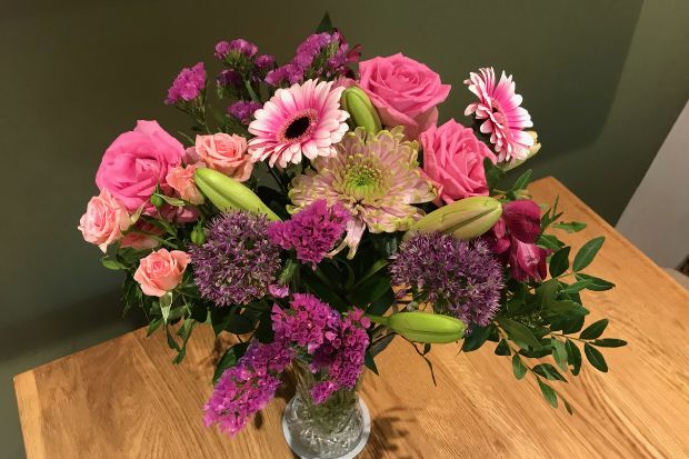 Bunches flower delivery in vase on a wooden table