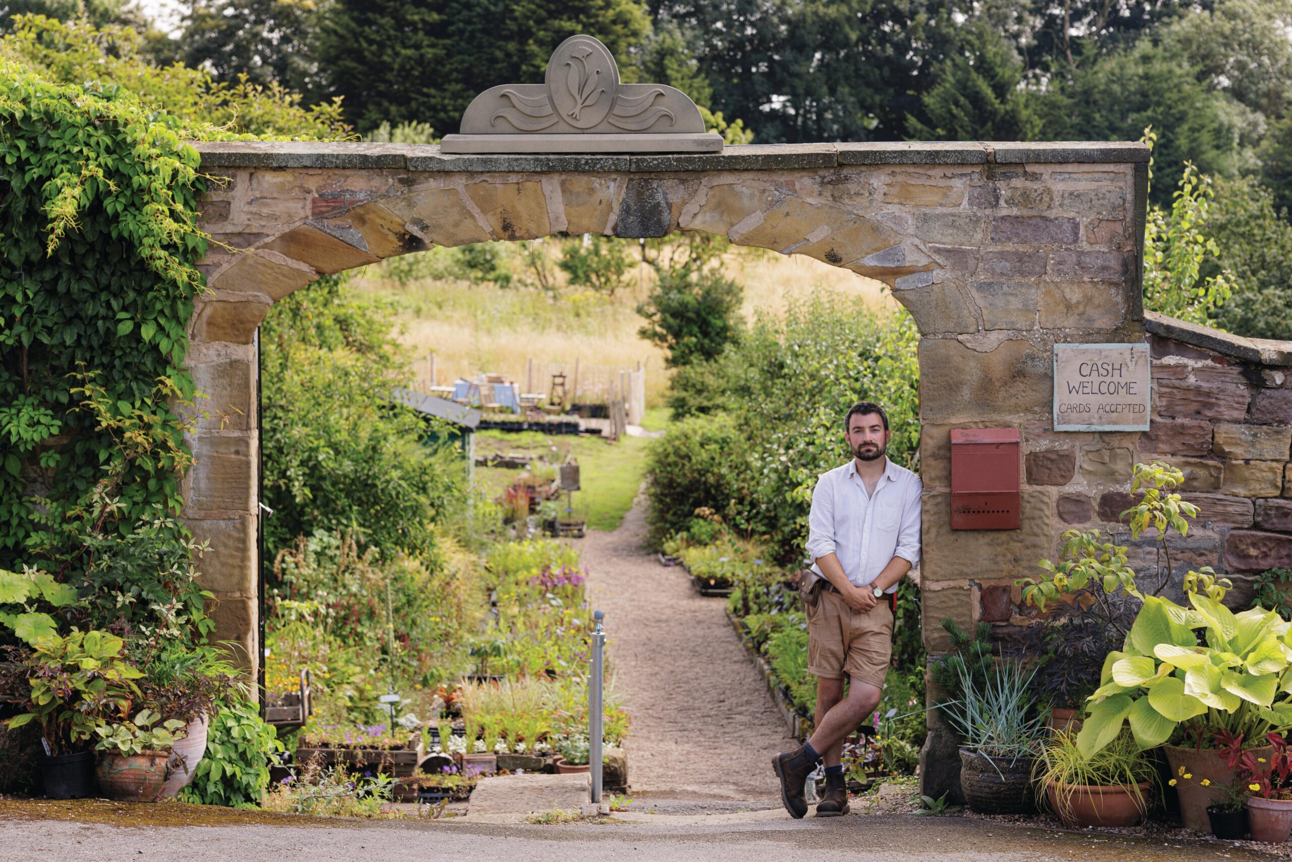 Man stood under garden stone archway
