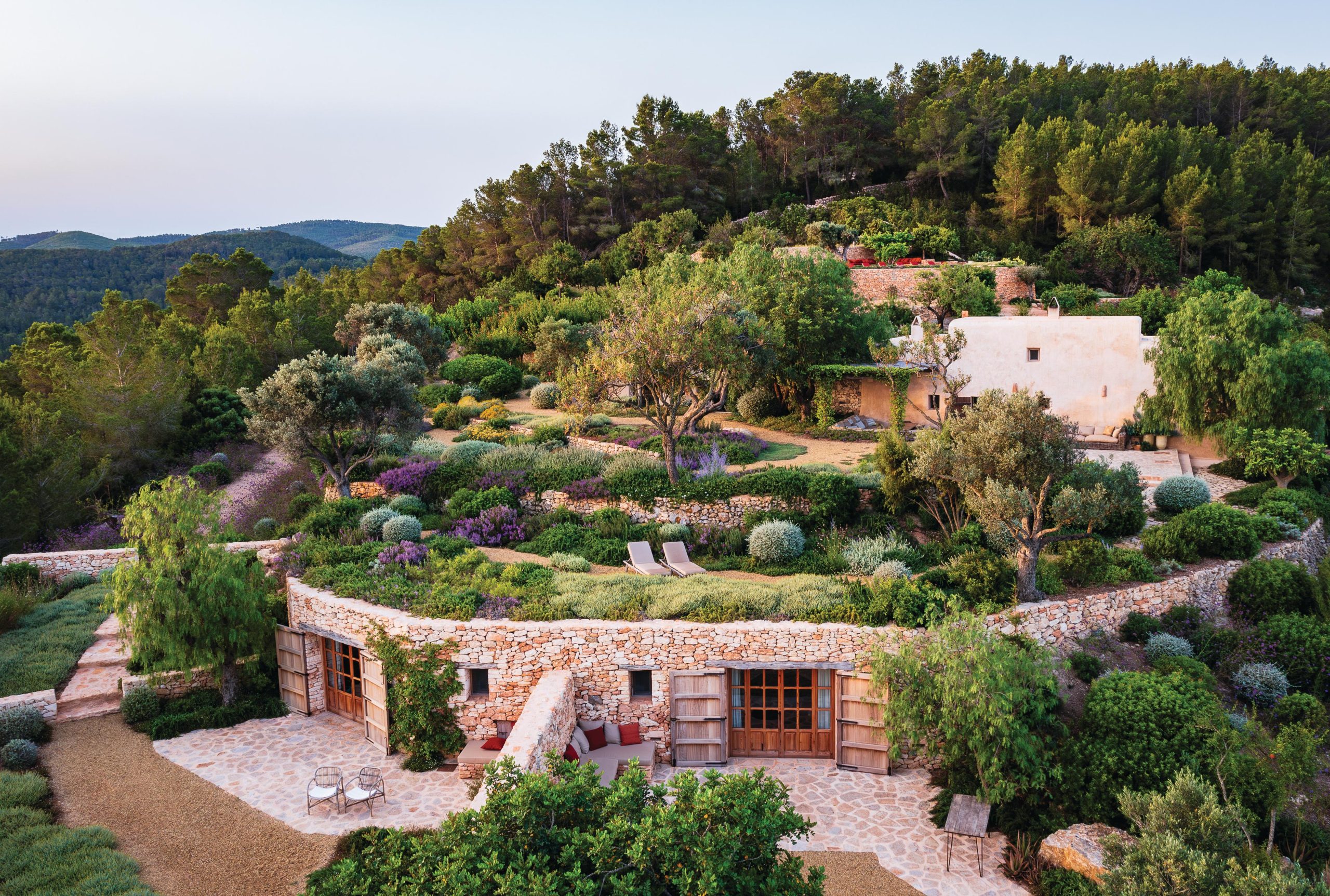 Stone house surrounded by forest and garden